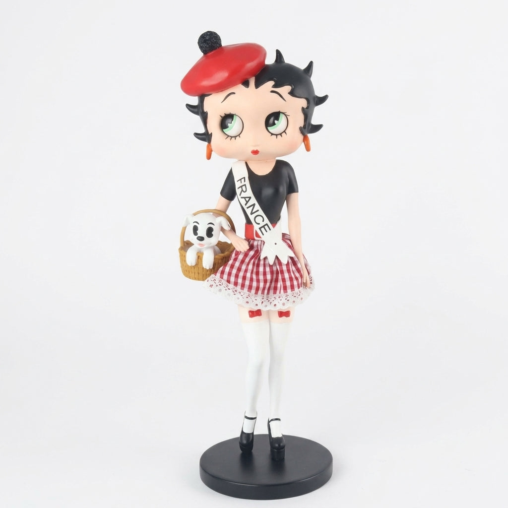 A Betty Boop figurine wearing a red beret, black top, red and white gingham skirt, white tights, and holding a small basket with a white dog, standing on a round black base against a white background.