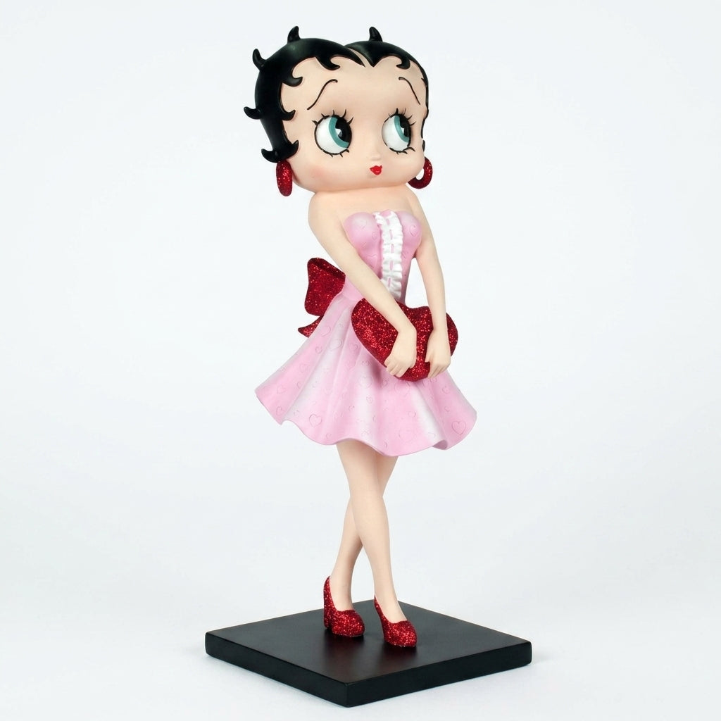 A collectible figurine of Betty Boop in a pink dress with red accents, standing on a black base against a white background.