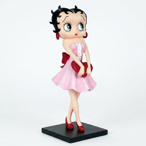 A collectible figurine of Betty Boop in a pink dress with red accents, standing on a black base against a white background.