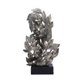 Decorative metal leaf sculpture on a black base against a white background mystic-cave