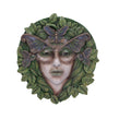 Decorative wall piece with a face surrounded by leaves and butterflies on a white background