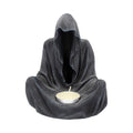 Gloomy figure in a dark hooded cloak holding a candle on a white background