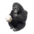 Statue of a gorilla holding a coconut on a white background