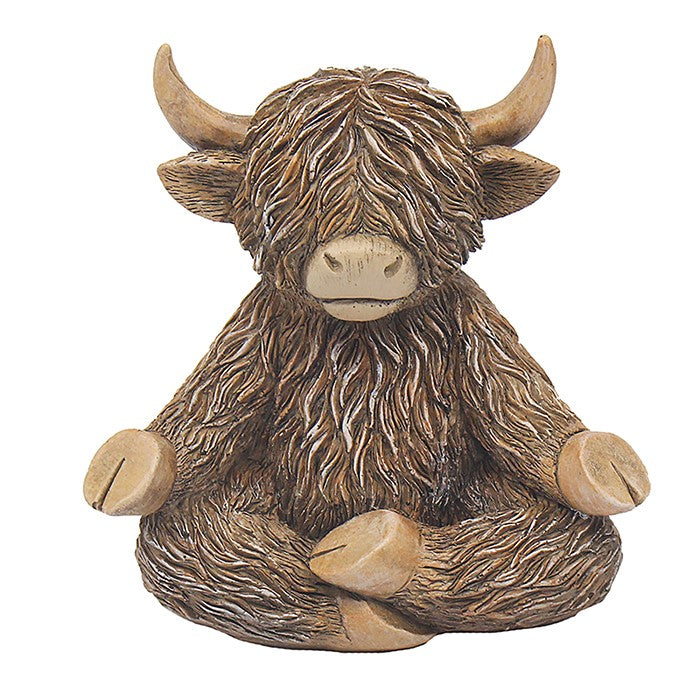 A decorative figurine of a seated Highland cow with long shaggy brown fur, cream-colored horns and muzzle, and tan hooves, shown on a plain white background.