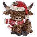 A decorative Highland cow figurine wearing a red Santa hat with white trim and a red-and-white striped scarf, shown on a plain white background.